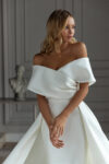 Elegant off-the-shoulder sheath wedding dress with a detachable overskirt